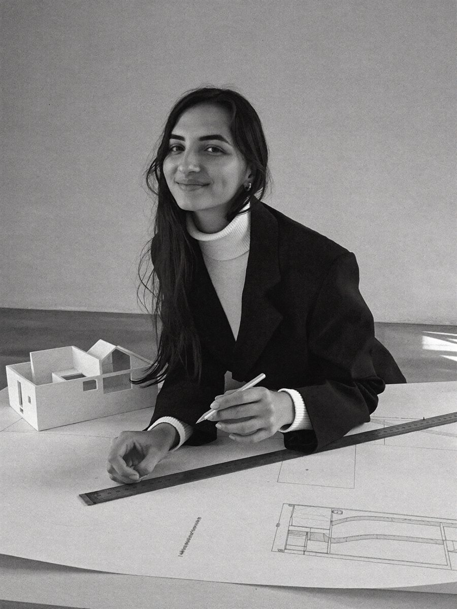 Tamara Badra, arquitecta de EMEBE, en su mesa de trabajo junto a una maqueta y planos de arquitectura